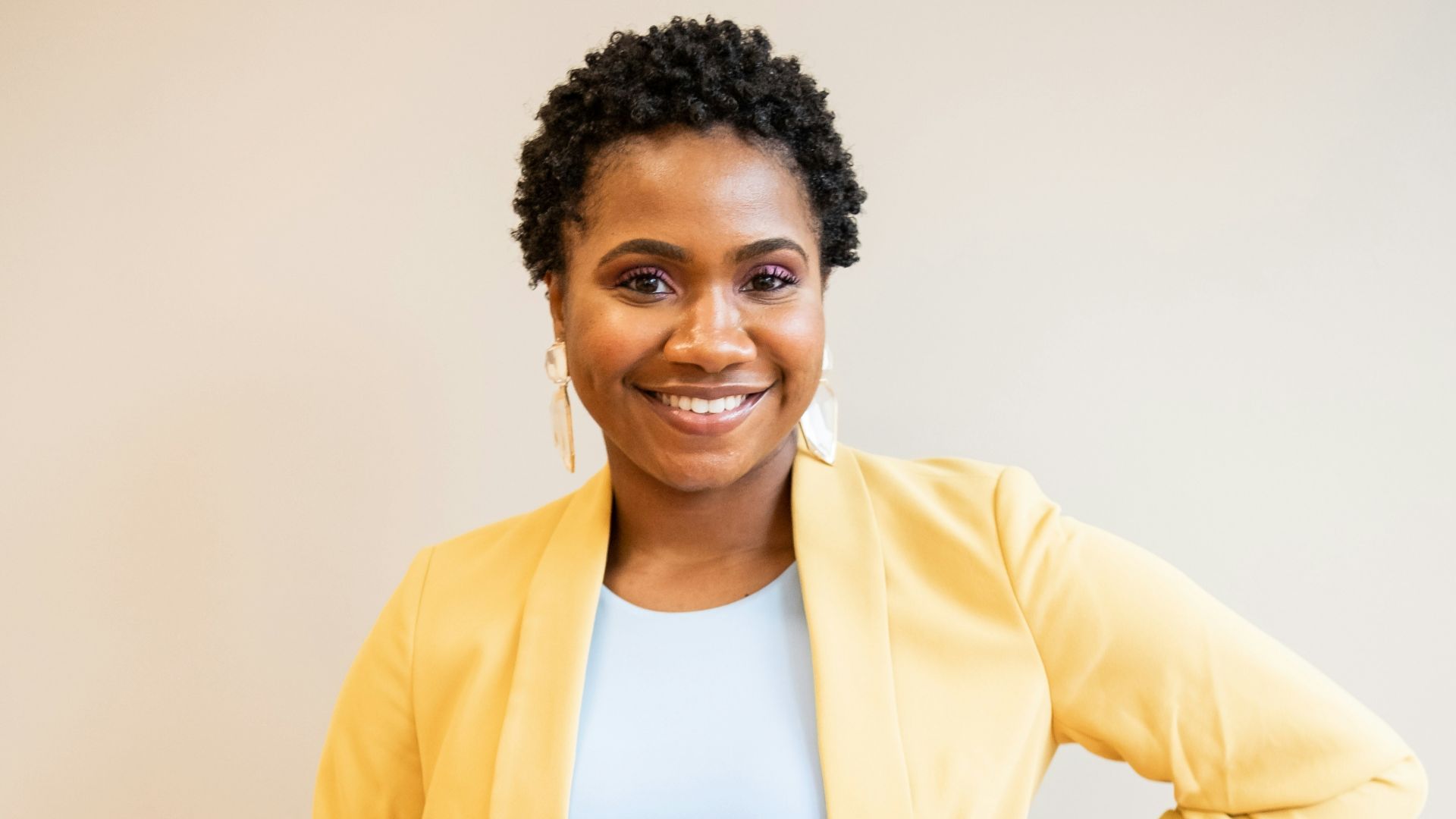 man in yellow blazer and blue denim jeans smiling