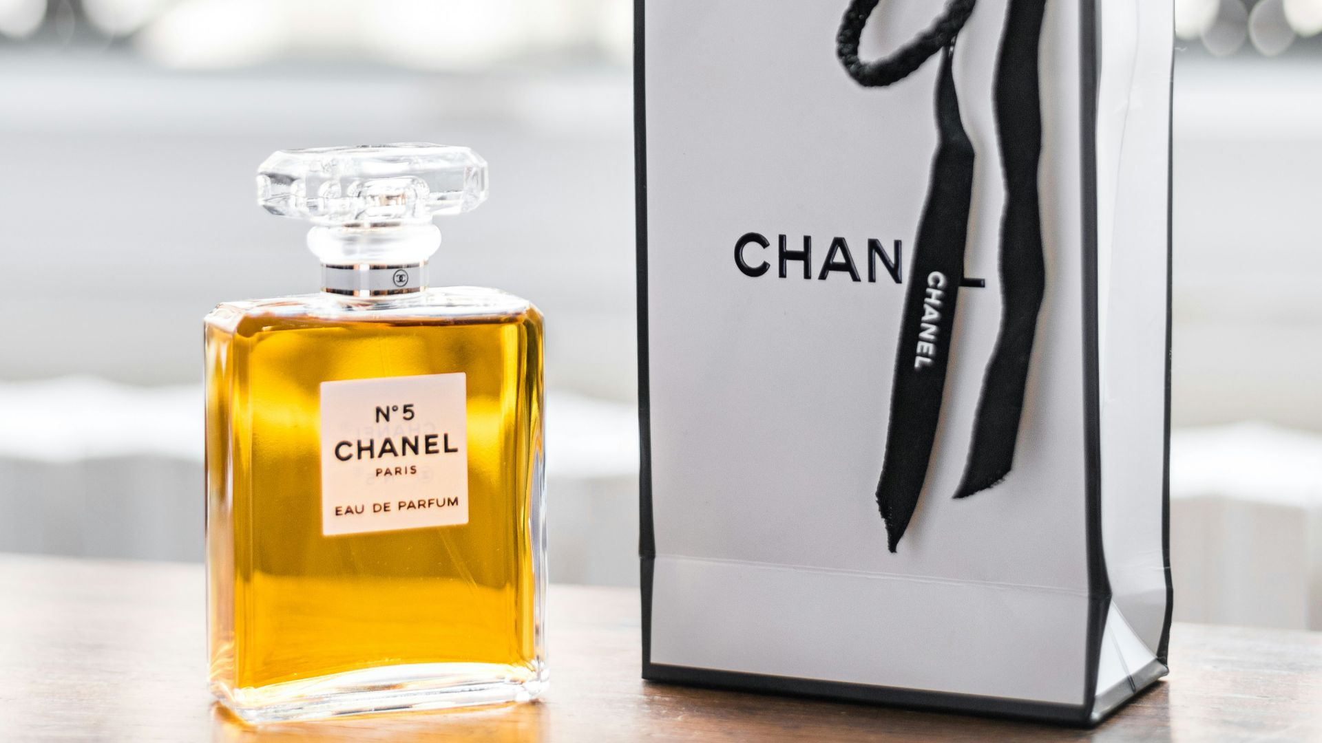 a bottle of chanel on a table next to a bag