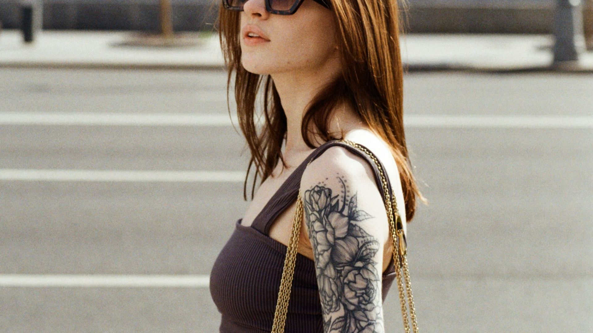 a woman with a tattoo on her arm holding a purse
