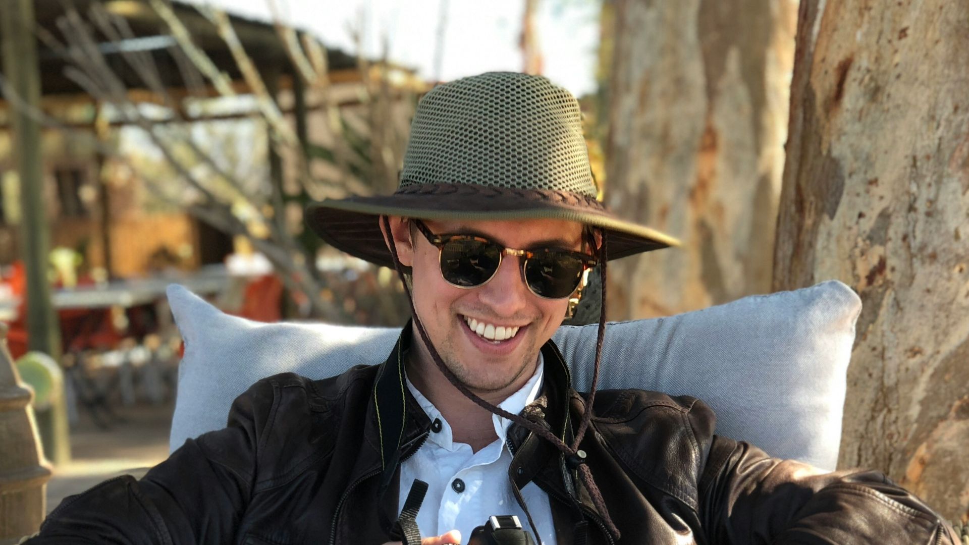 man sitting on chair while holding camera
