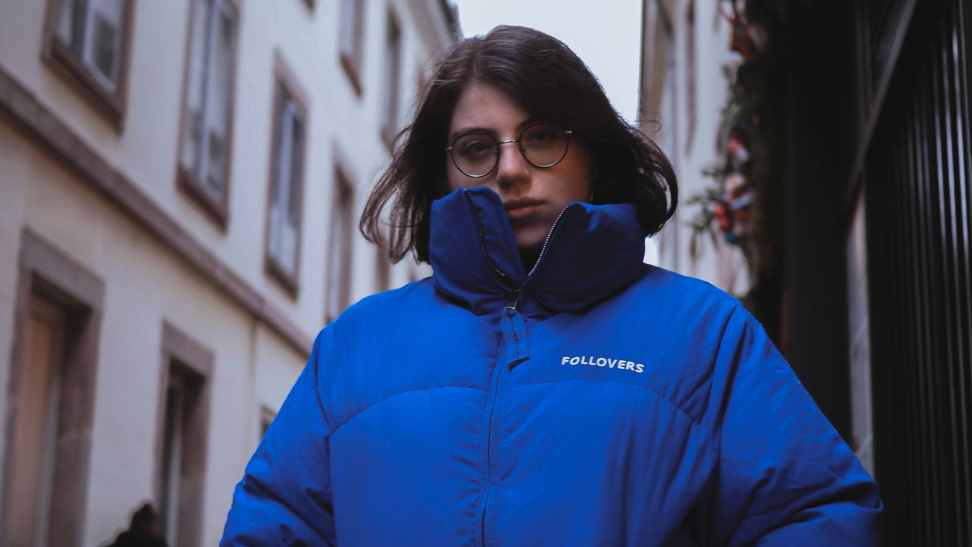 shallow focus photo of woman in blue full-zip bubble jacket