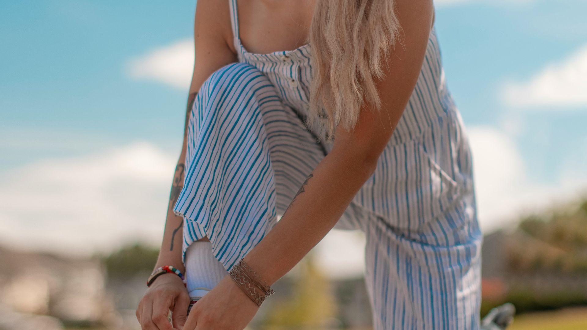 woman in white and blue striped spaghetti strap dress wearing sunglasses