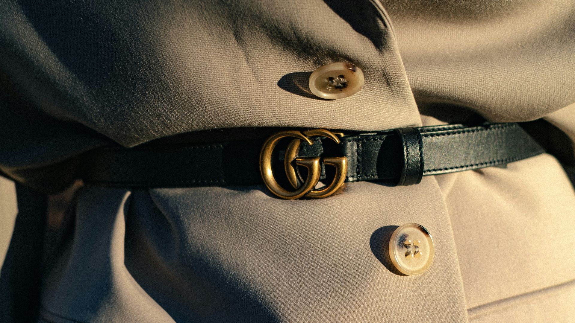 black leather belt on gray textile