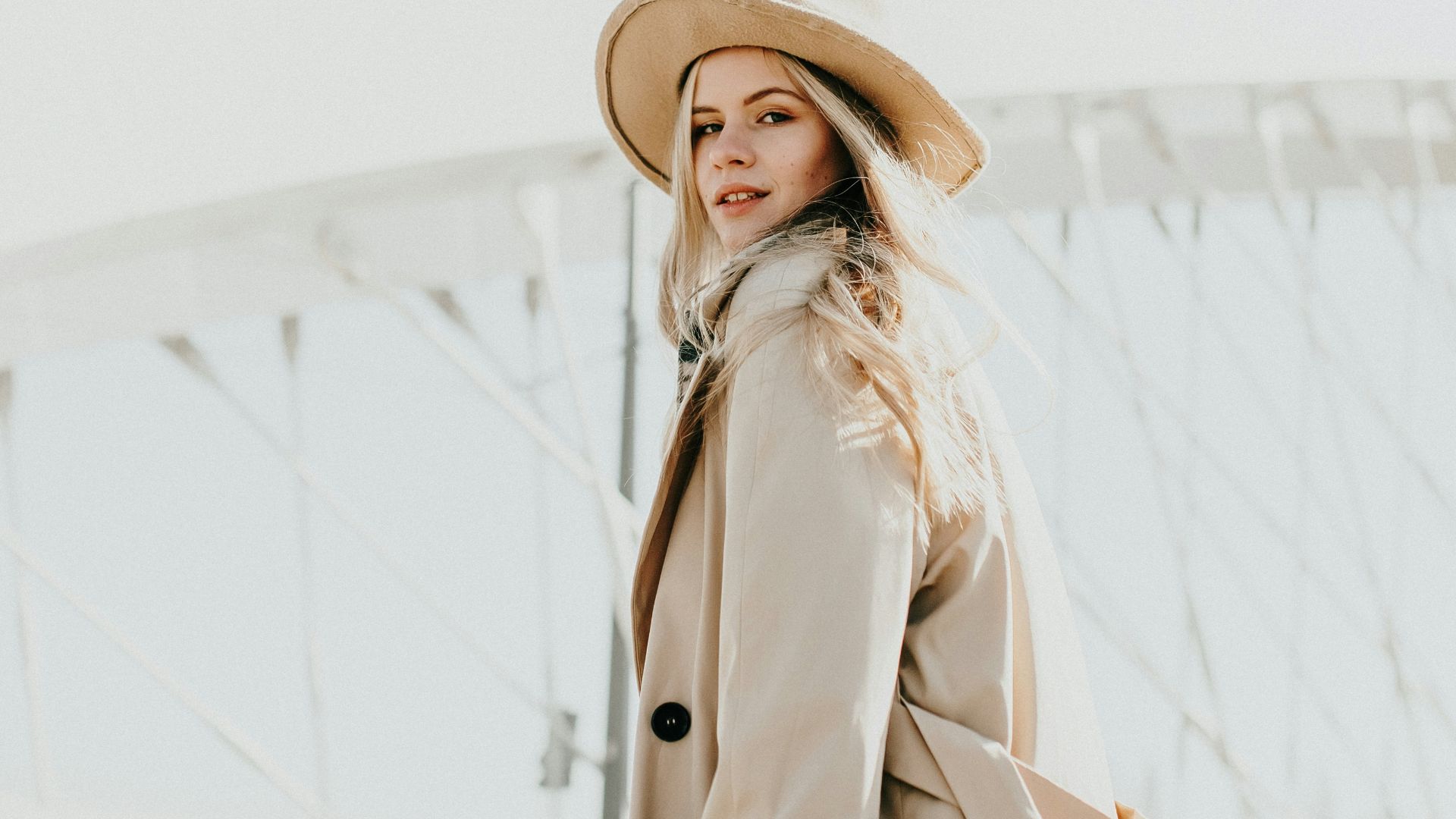 woman in brown coat wearing brown hat standing on snow covered ground during daytime