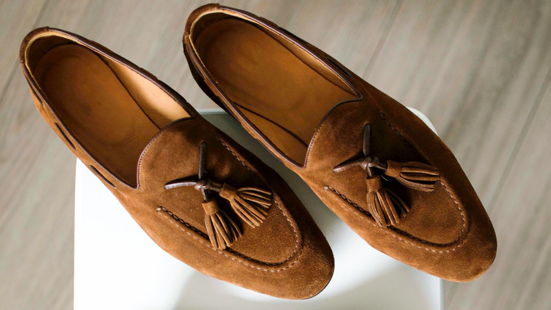 pair of brown loafers and blue polo shirt