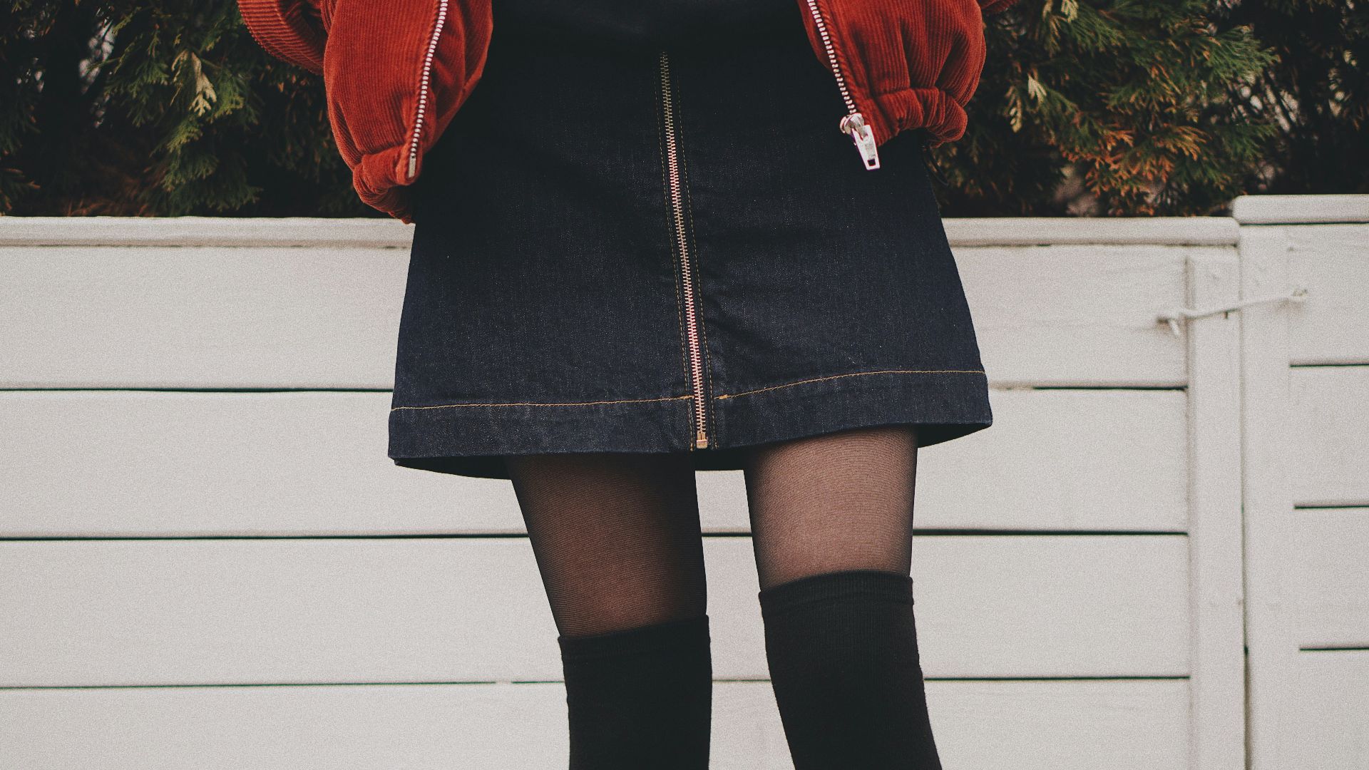 woman wearing black denim skirt and thigh high socks