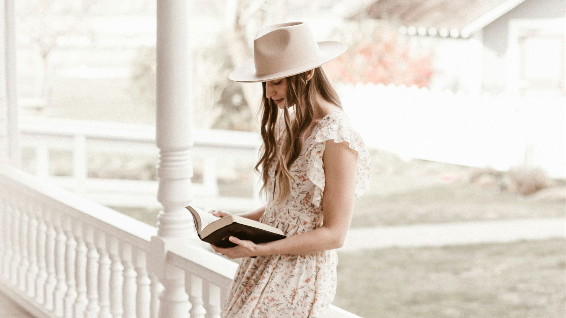 woman in white floral dress standing on wooden bridge