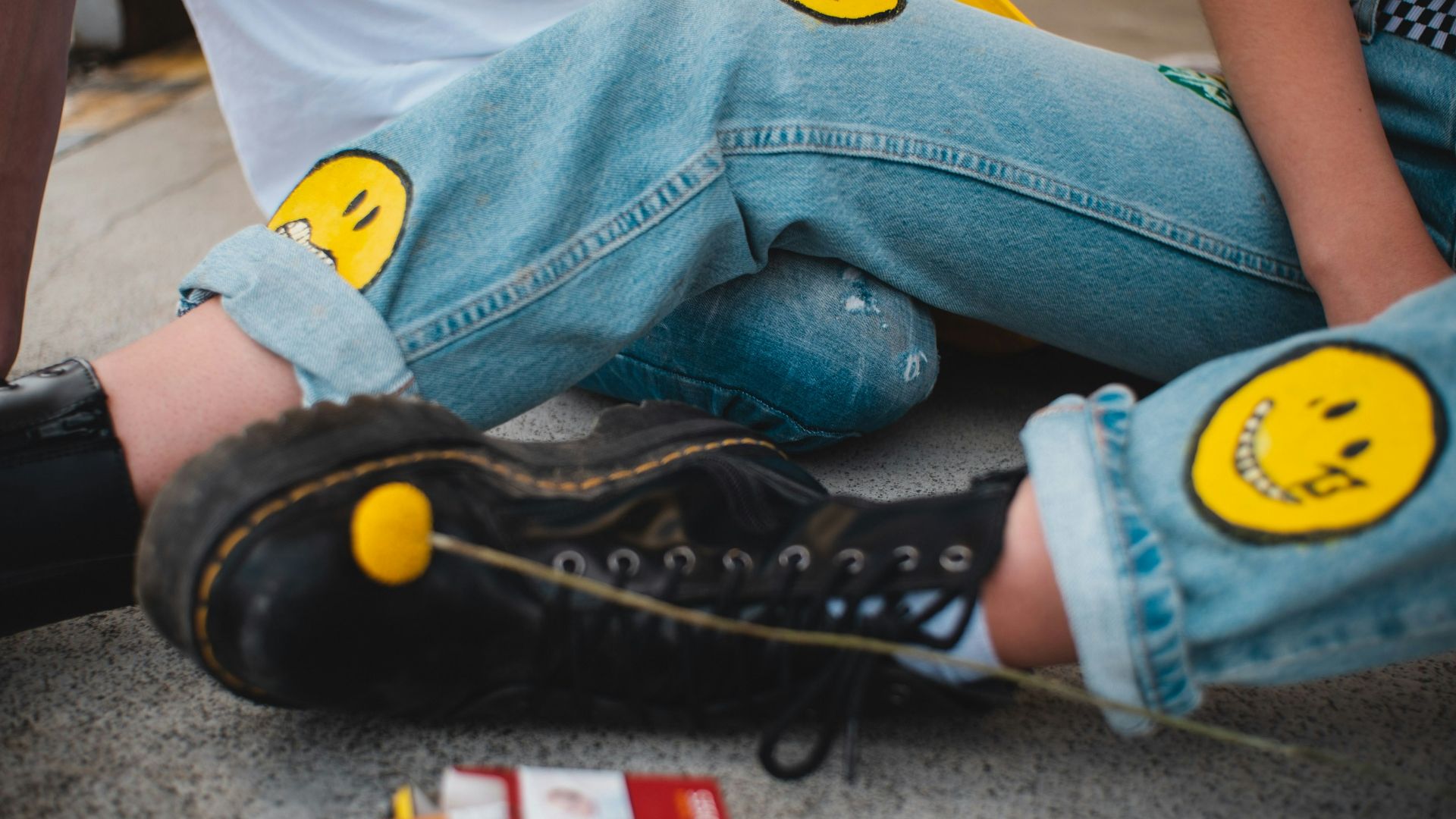 person in blue denim jeans and black converse all star high top sneakers