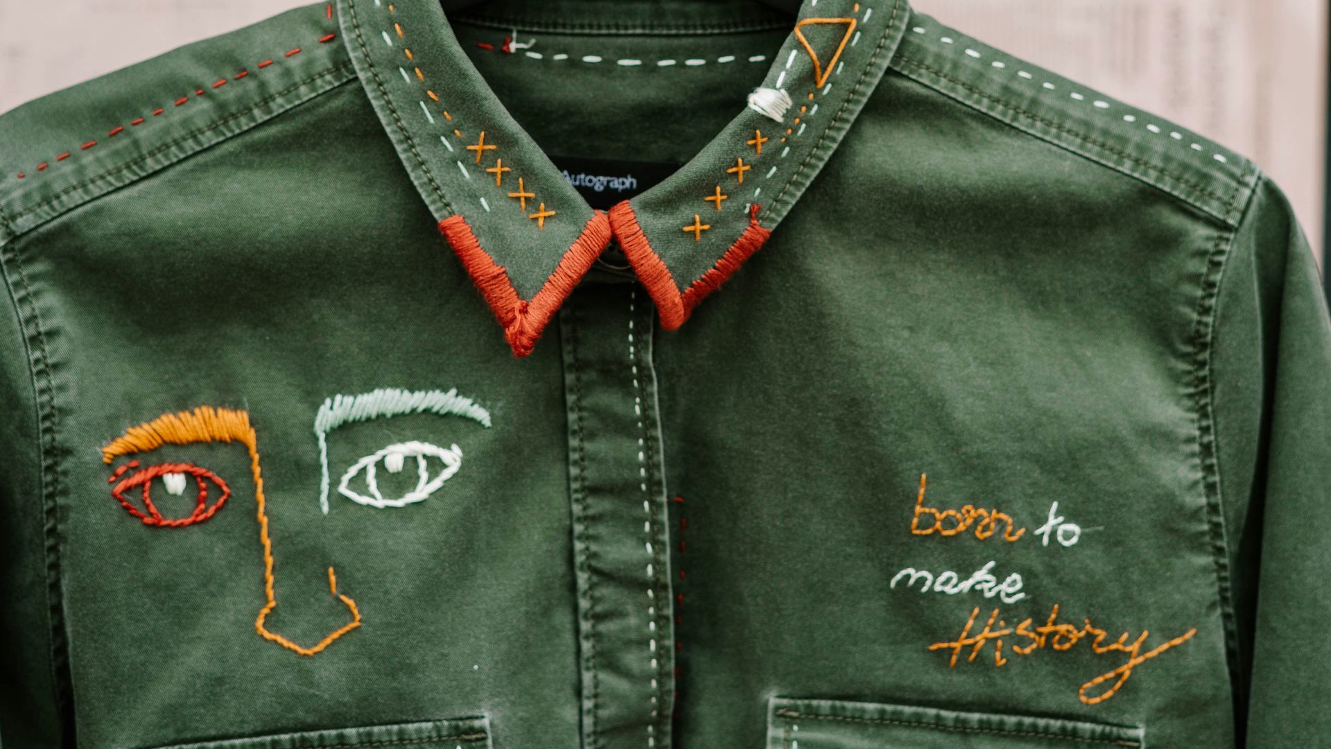 person holding black leather jacket with silver and black headphones