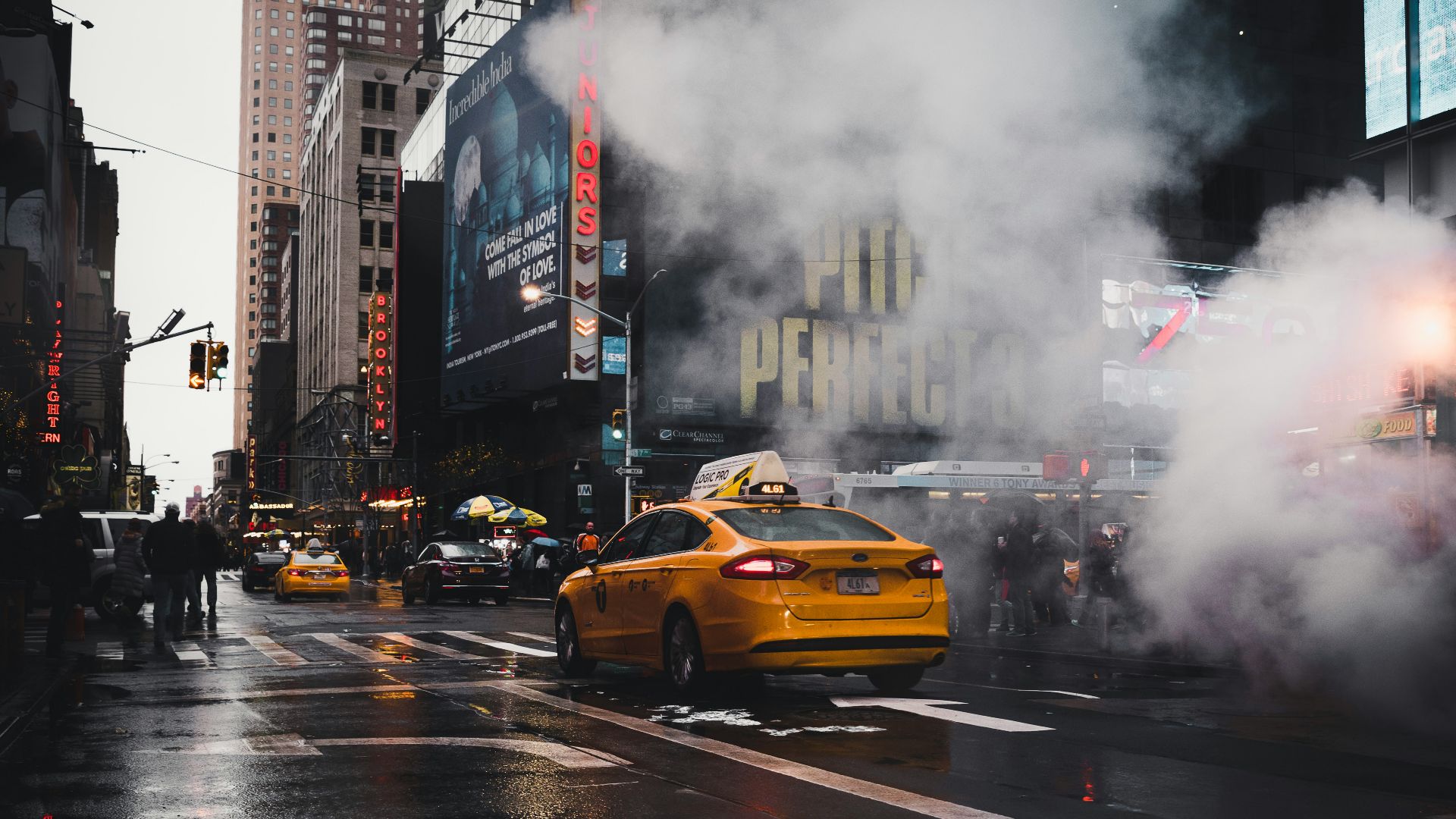 yellow taxi sedan on gray concrete street passed through white smokes near walking lane