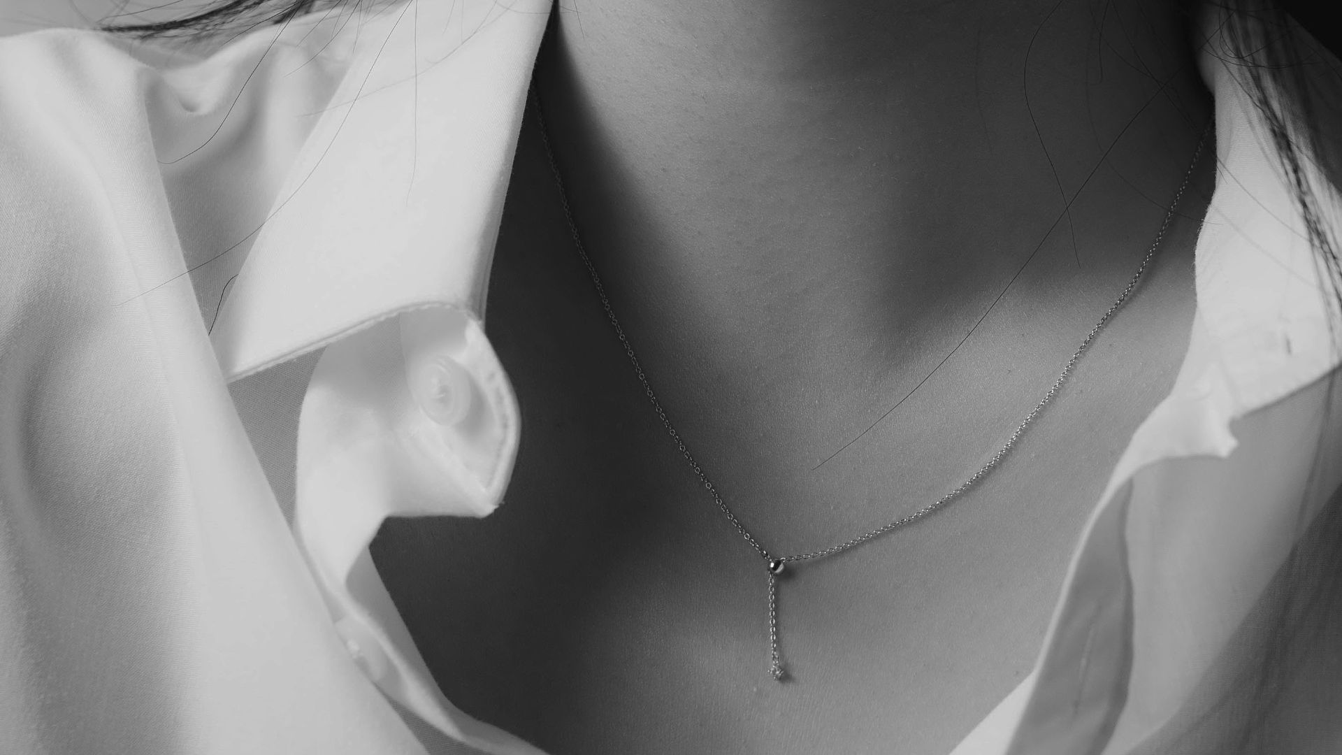 grayscale photo of woman wearing silver necklace
