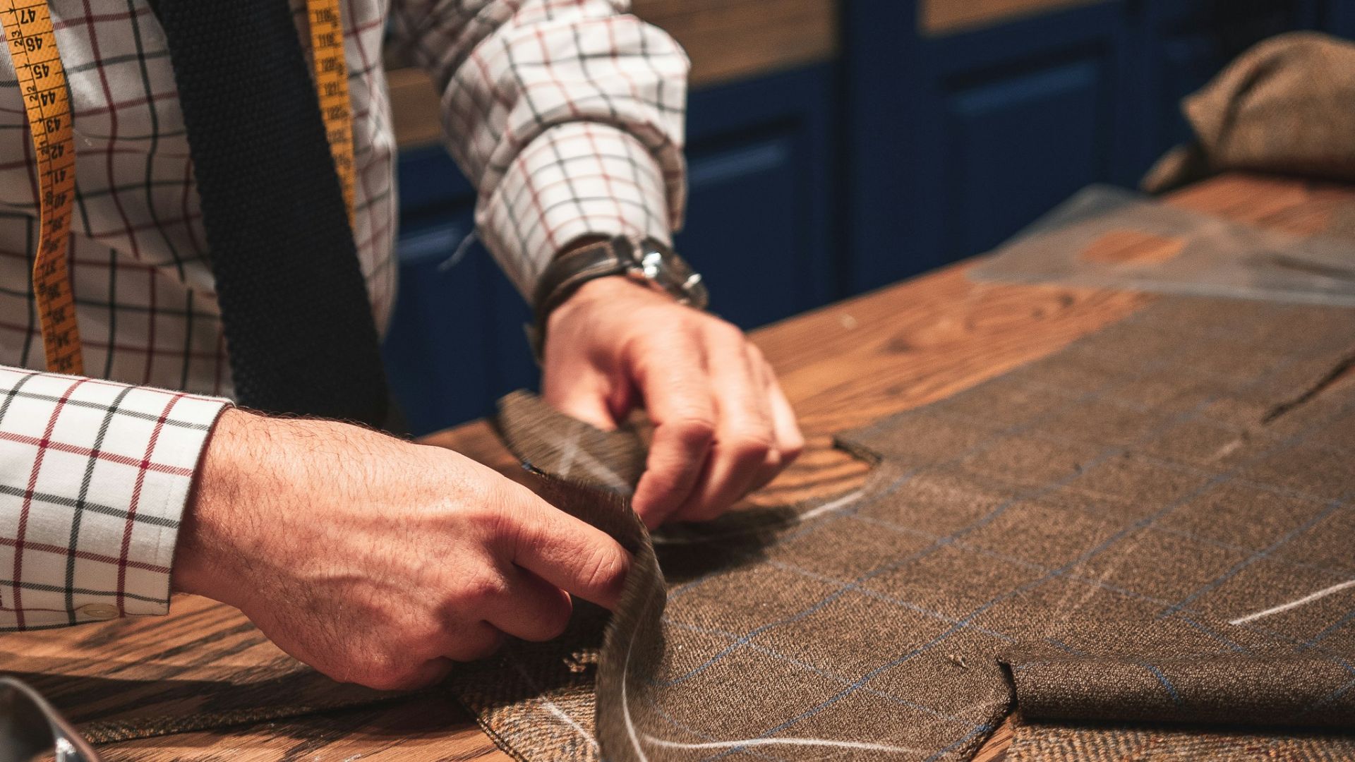 person in black suit holding brown leather bag