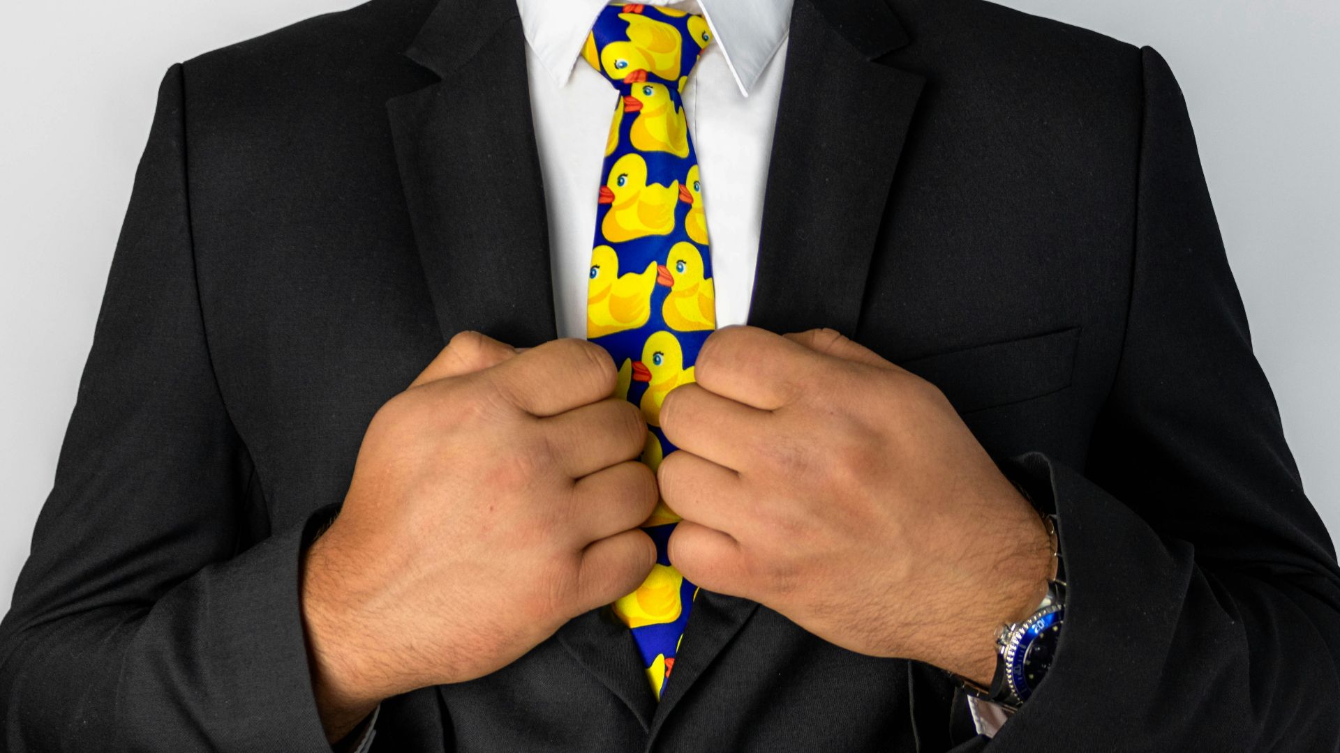 man in black suit jacket with blue necktie