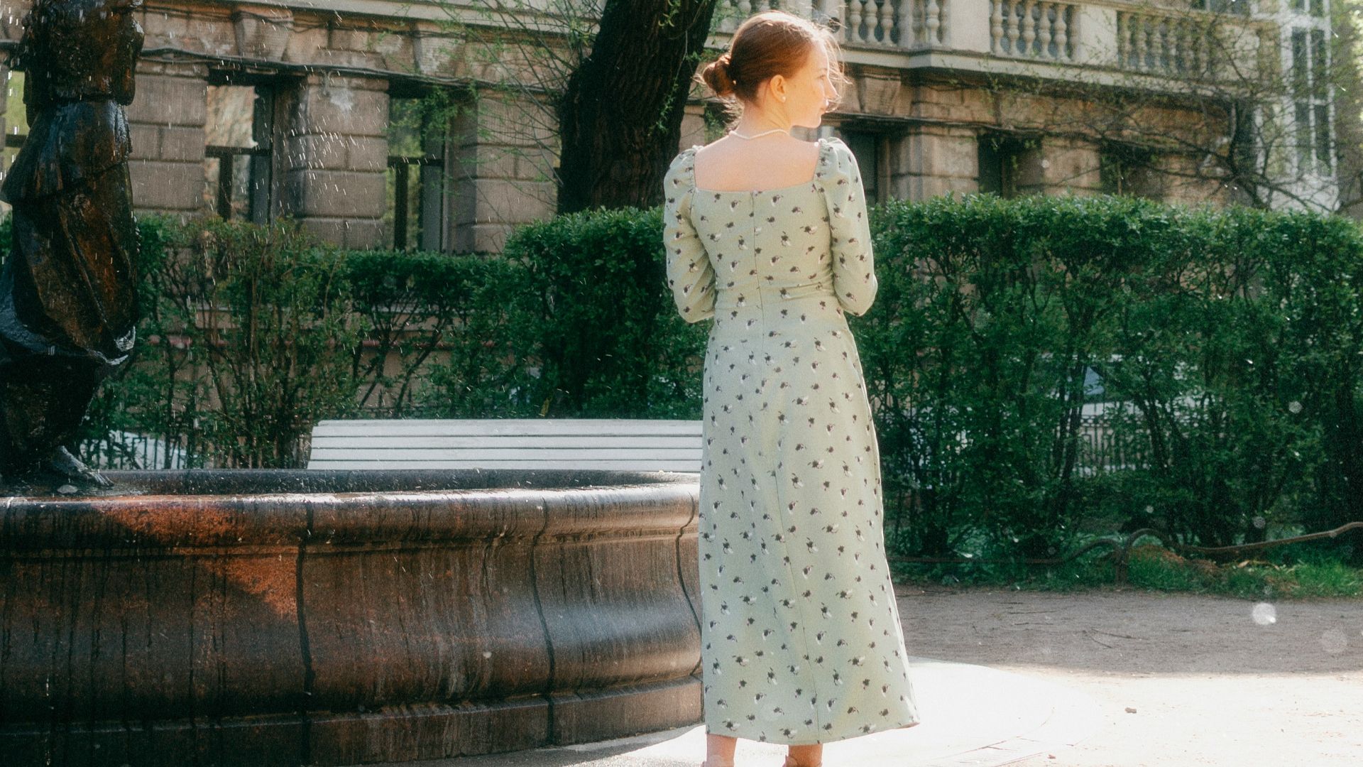 a woman standing in front of a fountain