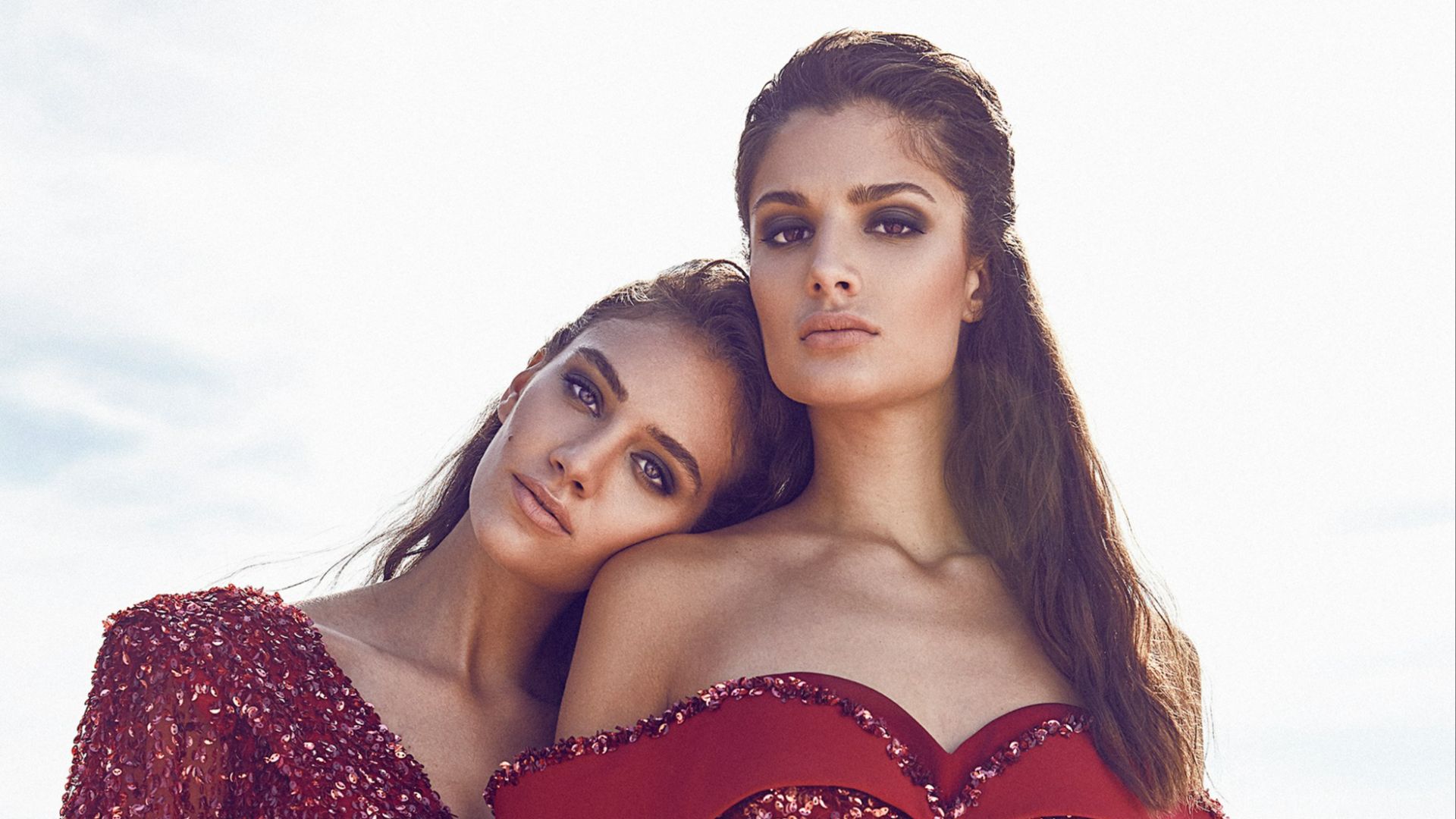 woman leaning to woman wearing dresses