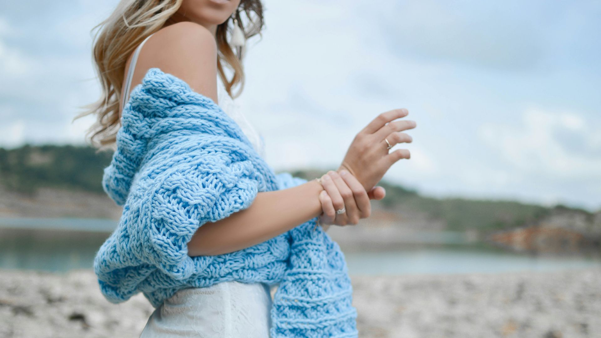 woman wearing teal crochet top and white skirt