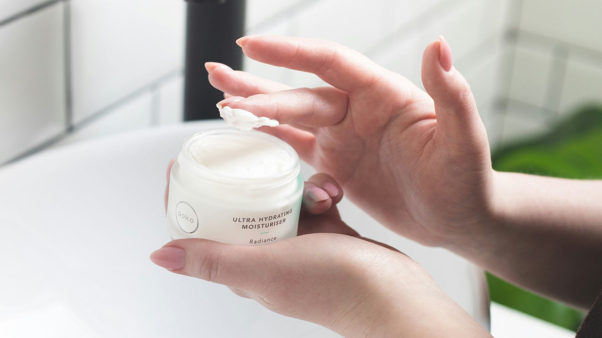 person holding white and black plastic bottle