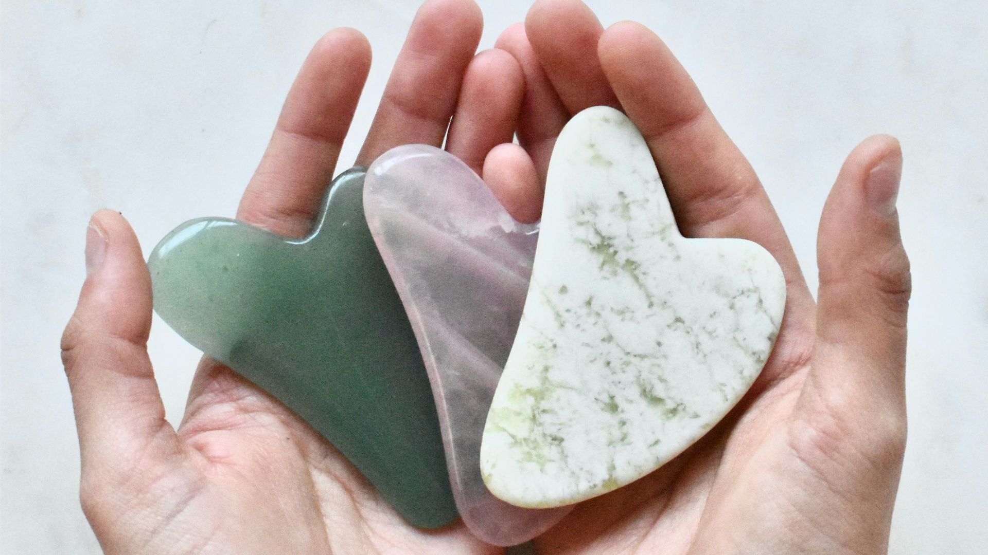 two hands holding two heart shaped pieces of soap