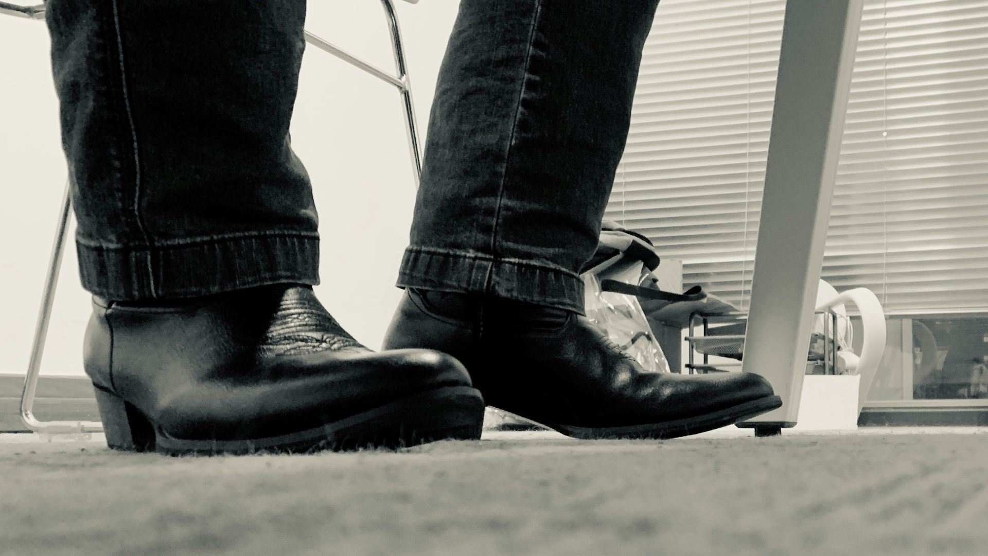 a black and white photo of a person's legs and shoes