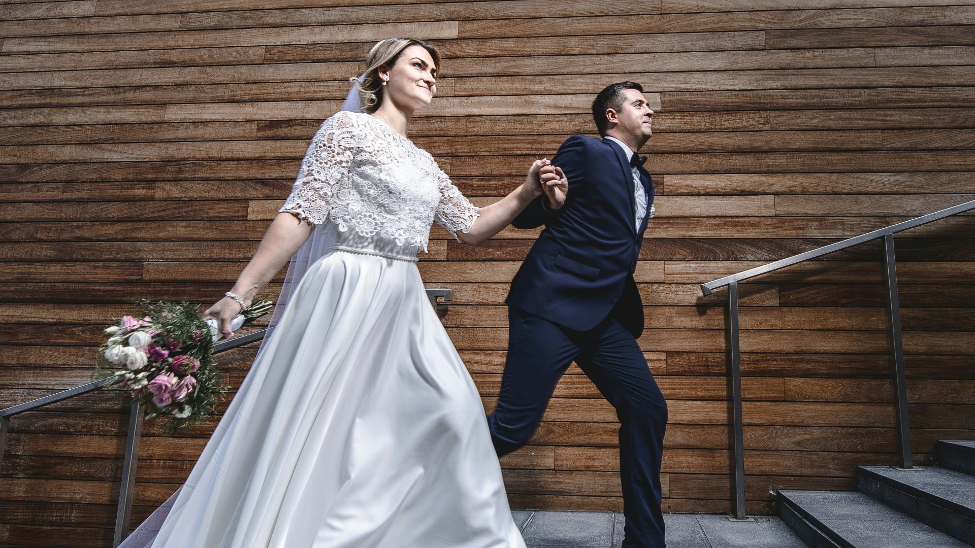 a bride and groom walking down a flight of stairs