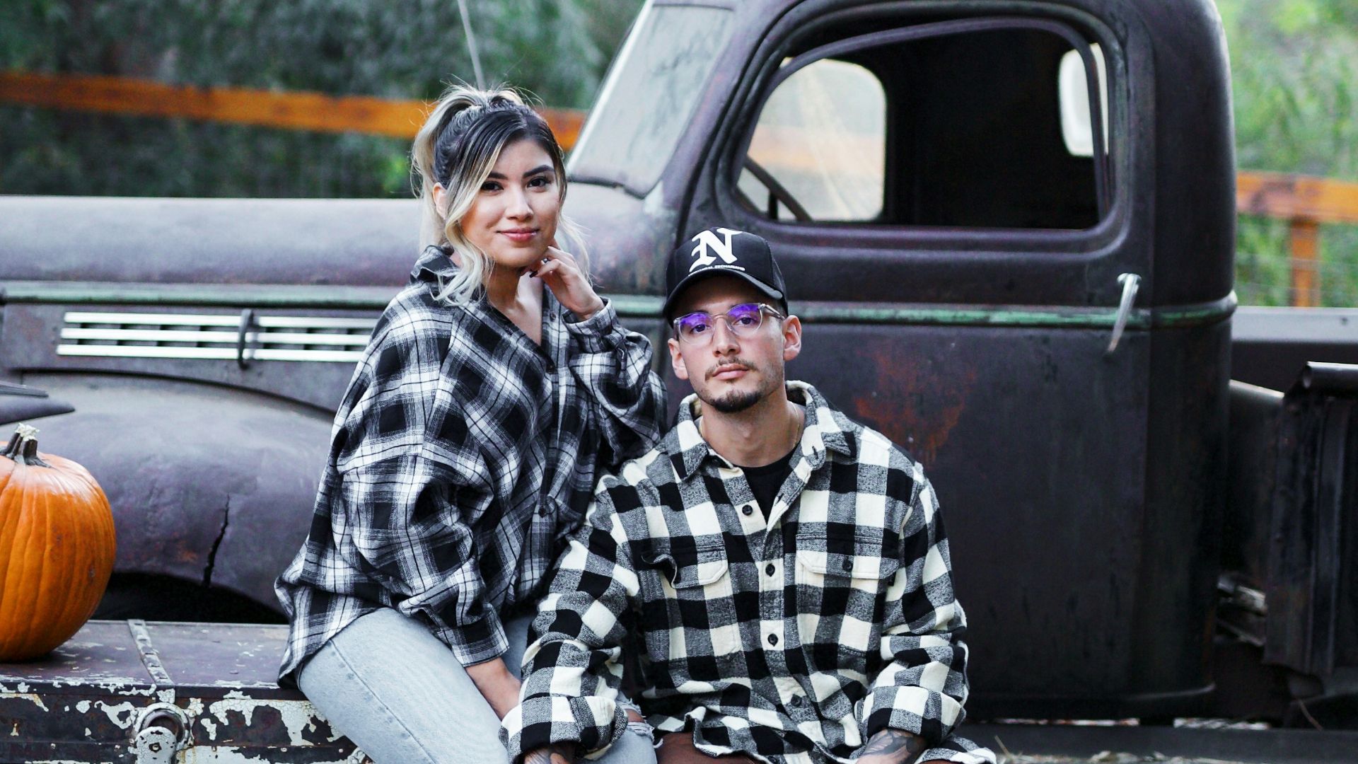 man in black and white checkered dress shirt sitting on black truck during daytime