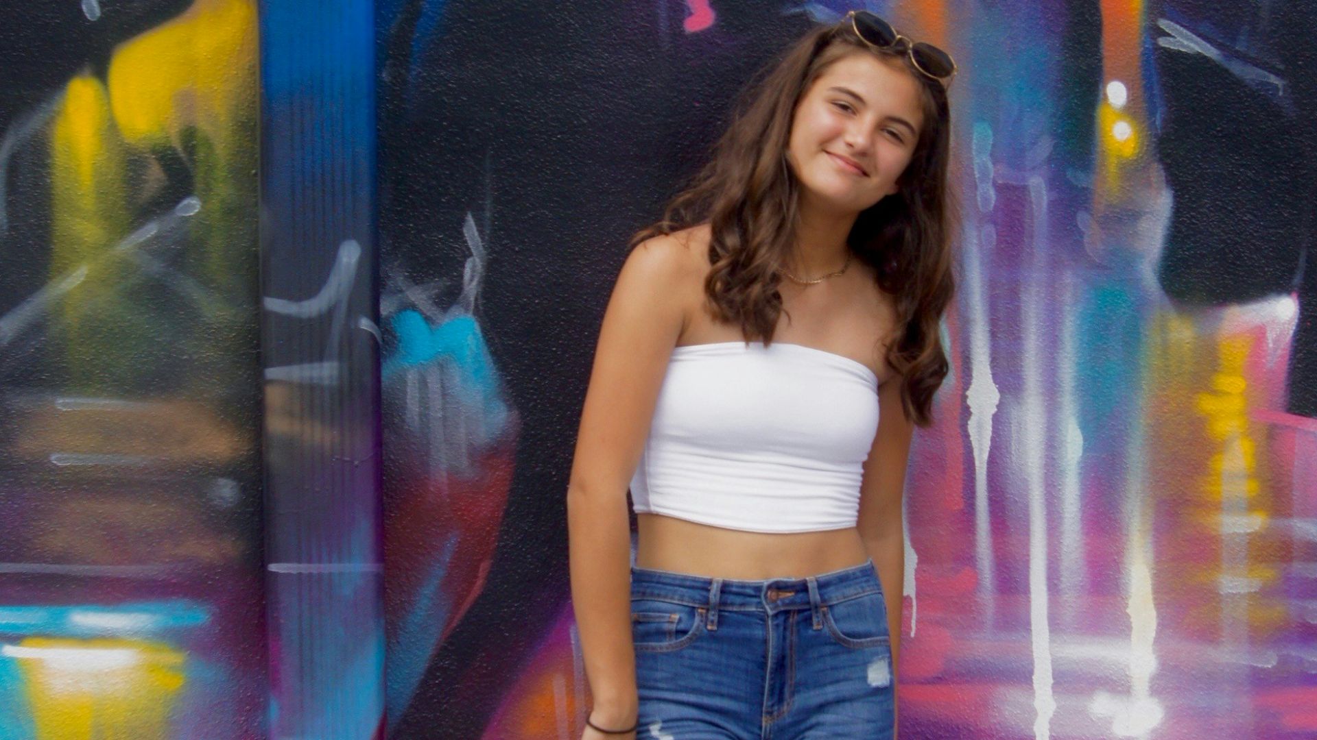 woman in white tank top and blue denim jeans