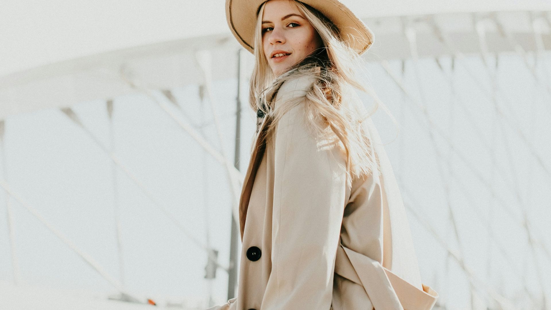 woman in brown coat wearing brown hat standing on snow covered ground during daytime