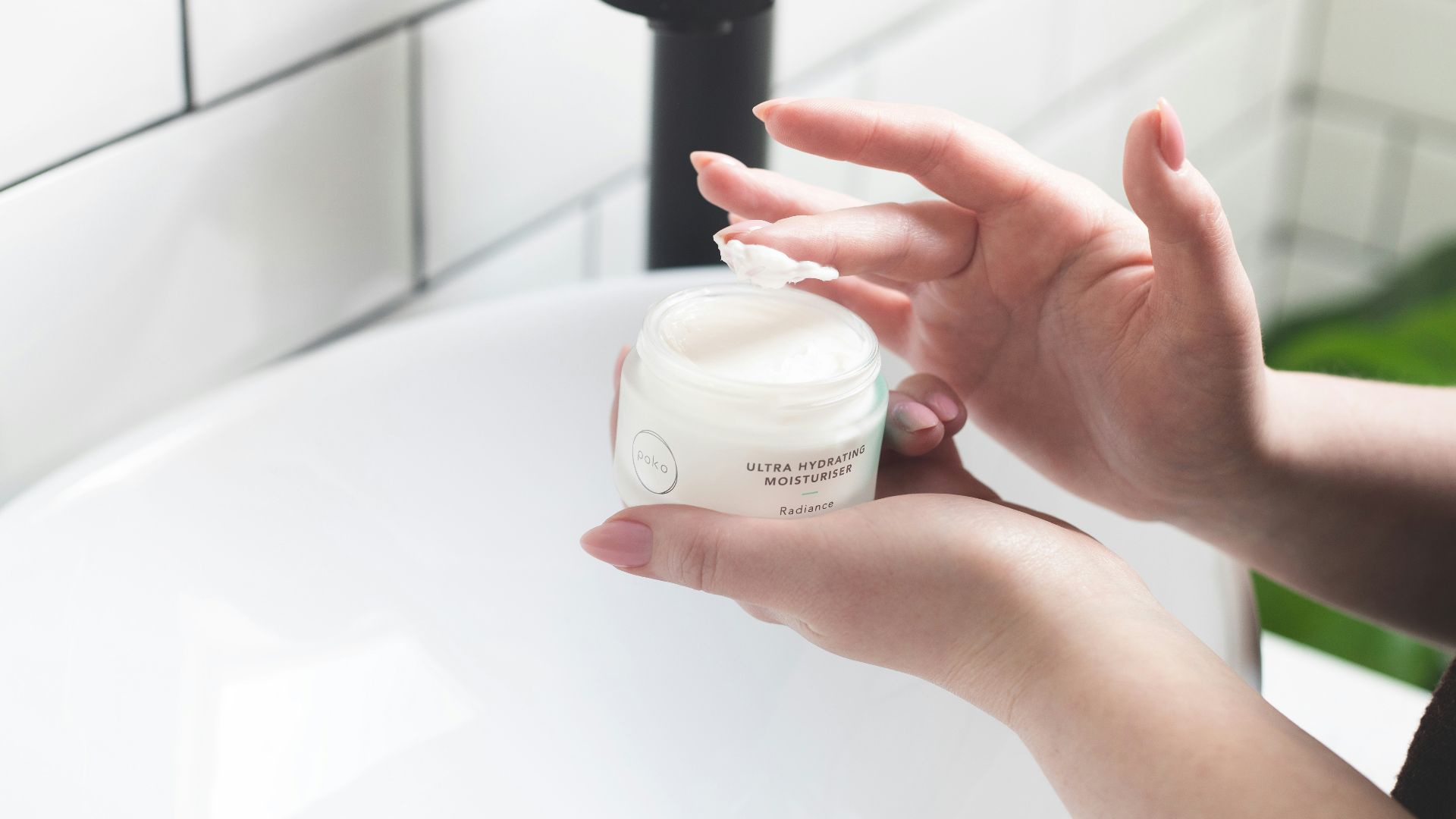 person holding white and black plastic bottle