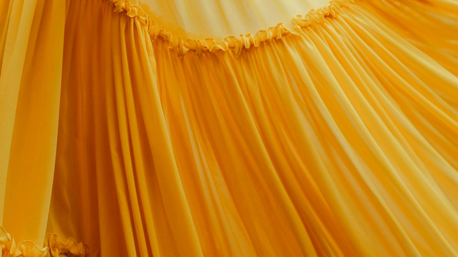 woman wearing yellow long-sleeved dress under white clouds and blue sky during daytime