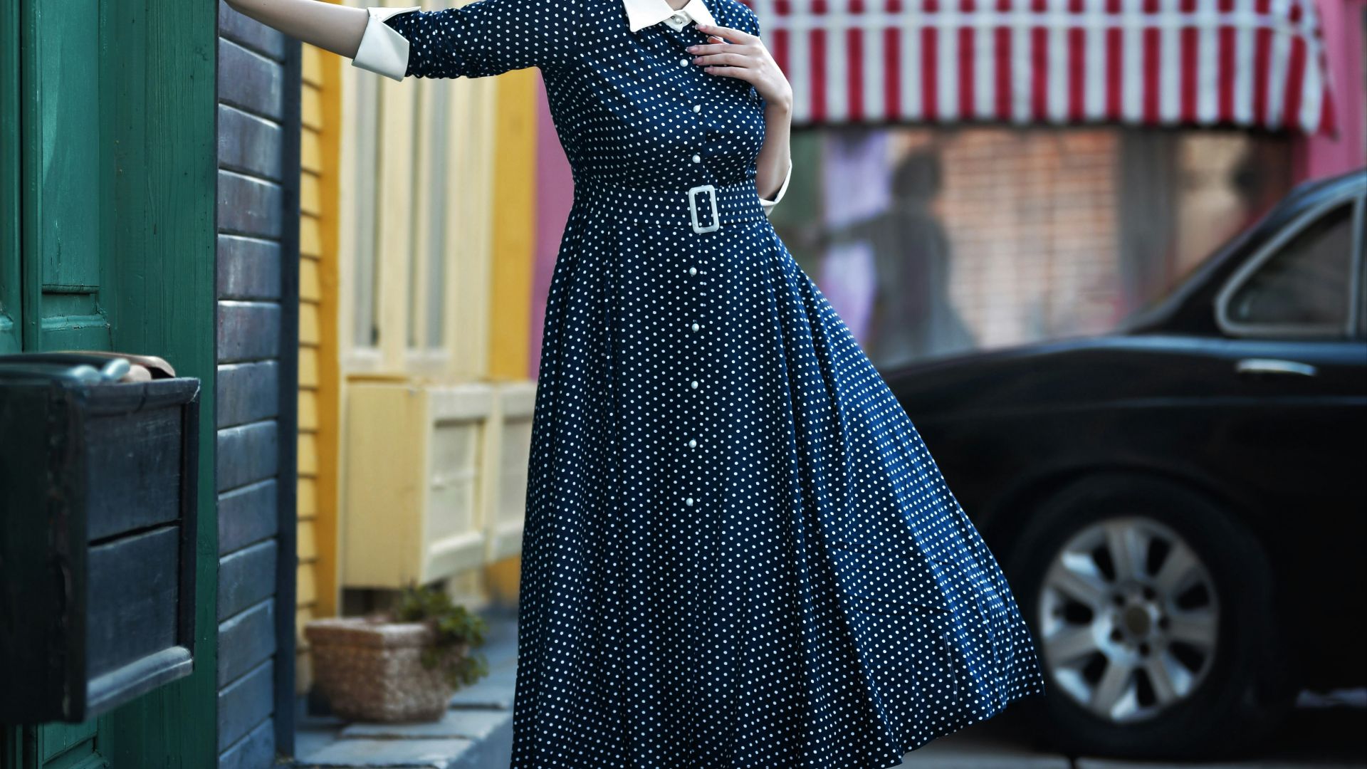 a woman in a blue dress is holding a sign