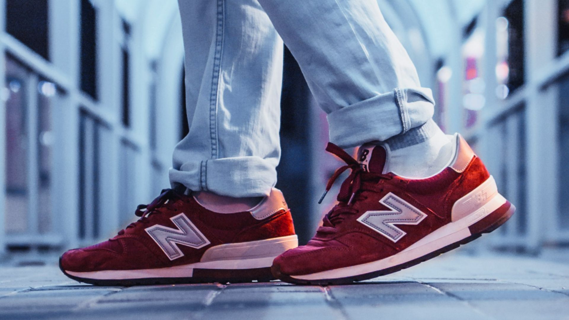 person wearing pair of red New Balance low-top sneakers