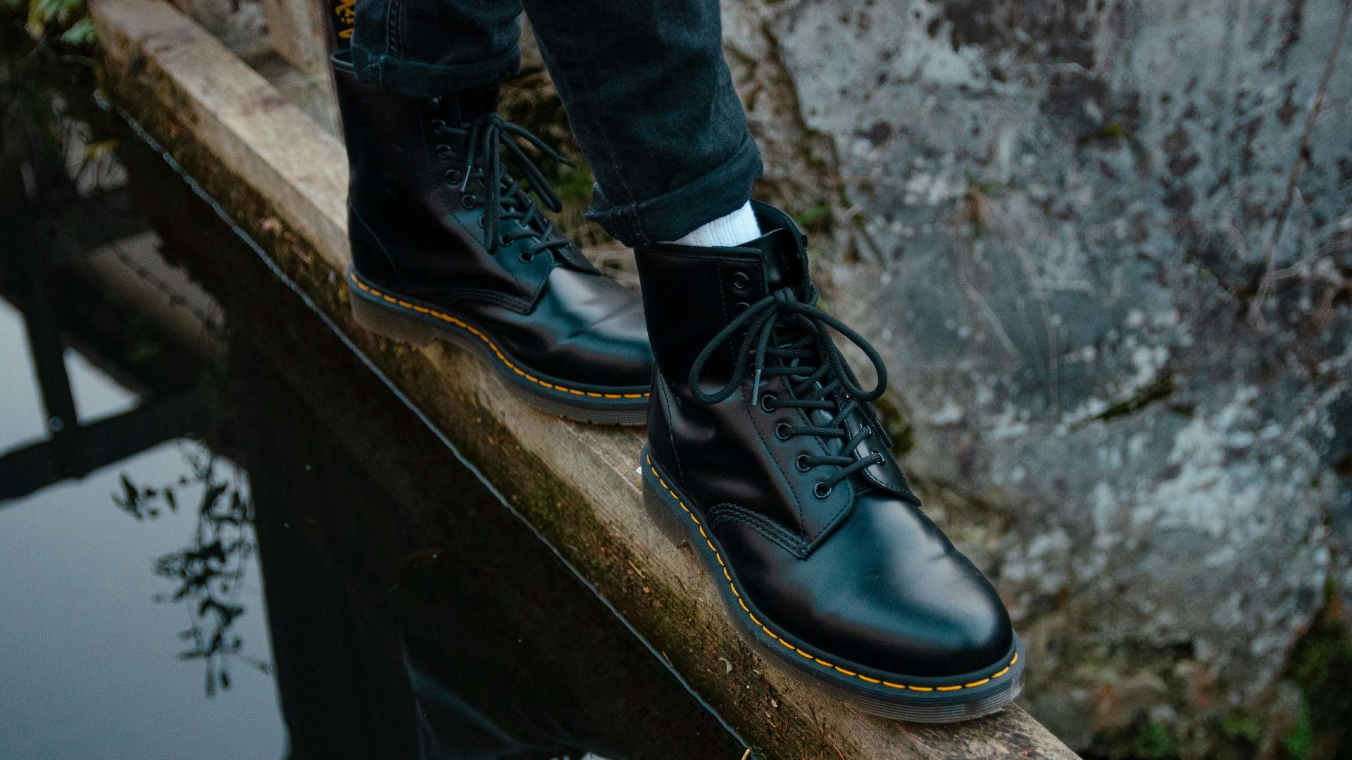 person stepping on brown wooden panel