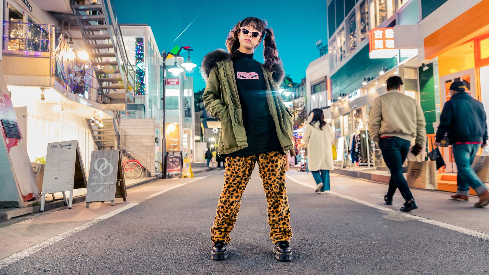 woman in green jacket stands and pose on street