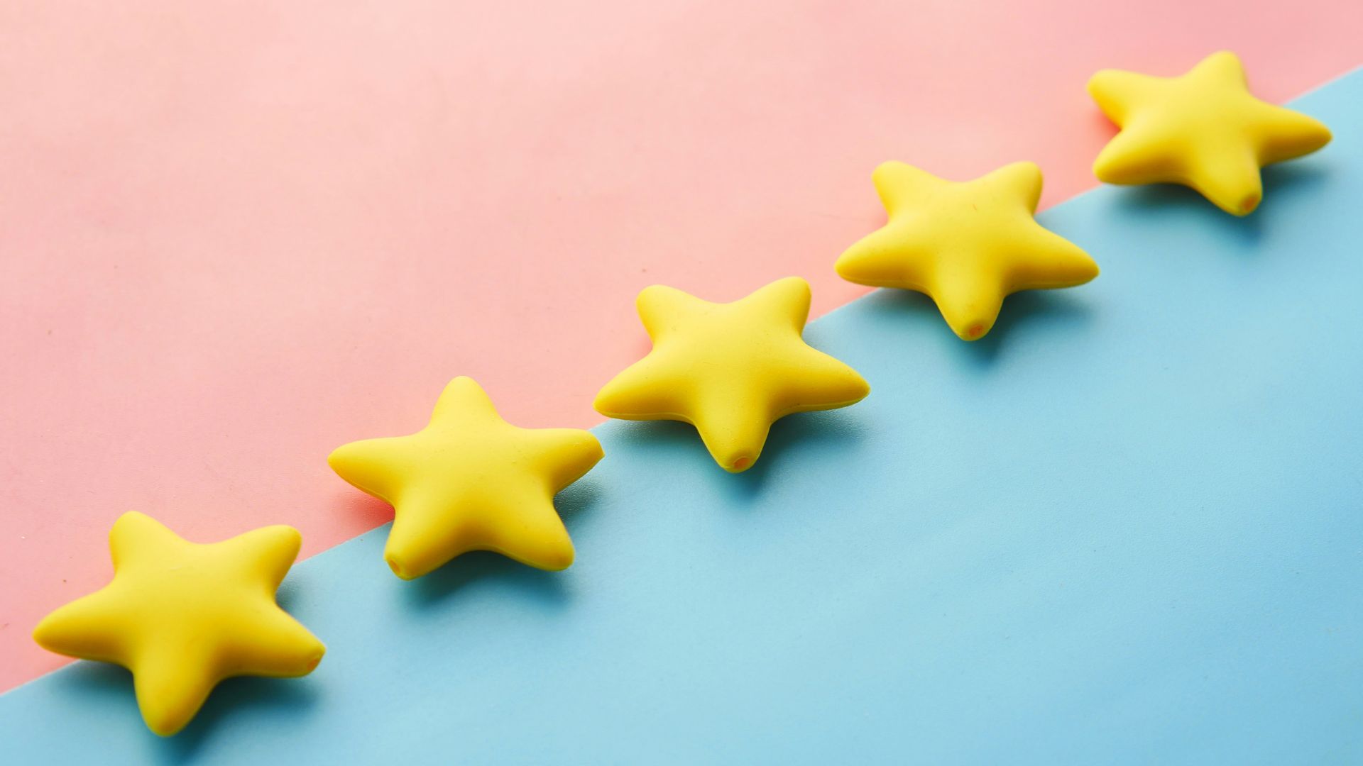 a row of yellow stars sitting on top of a blue and pink surface