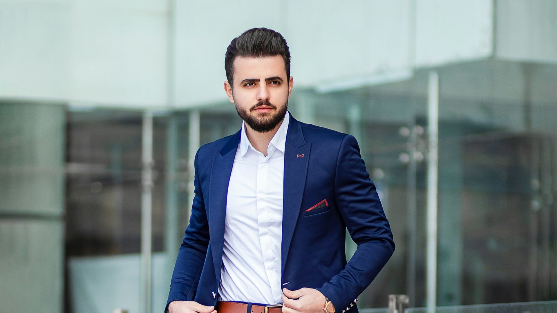 man in blue suit standing on sidewalk during daytime