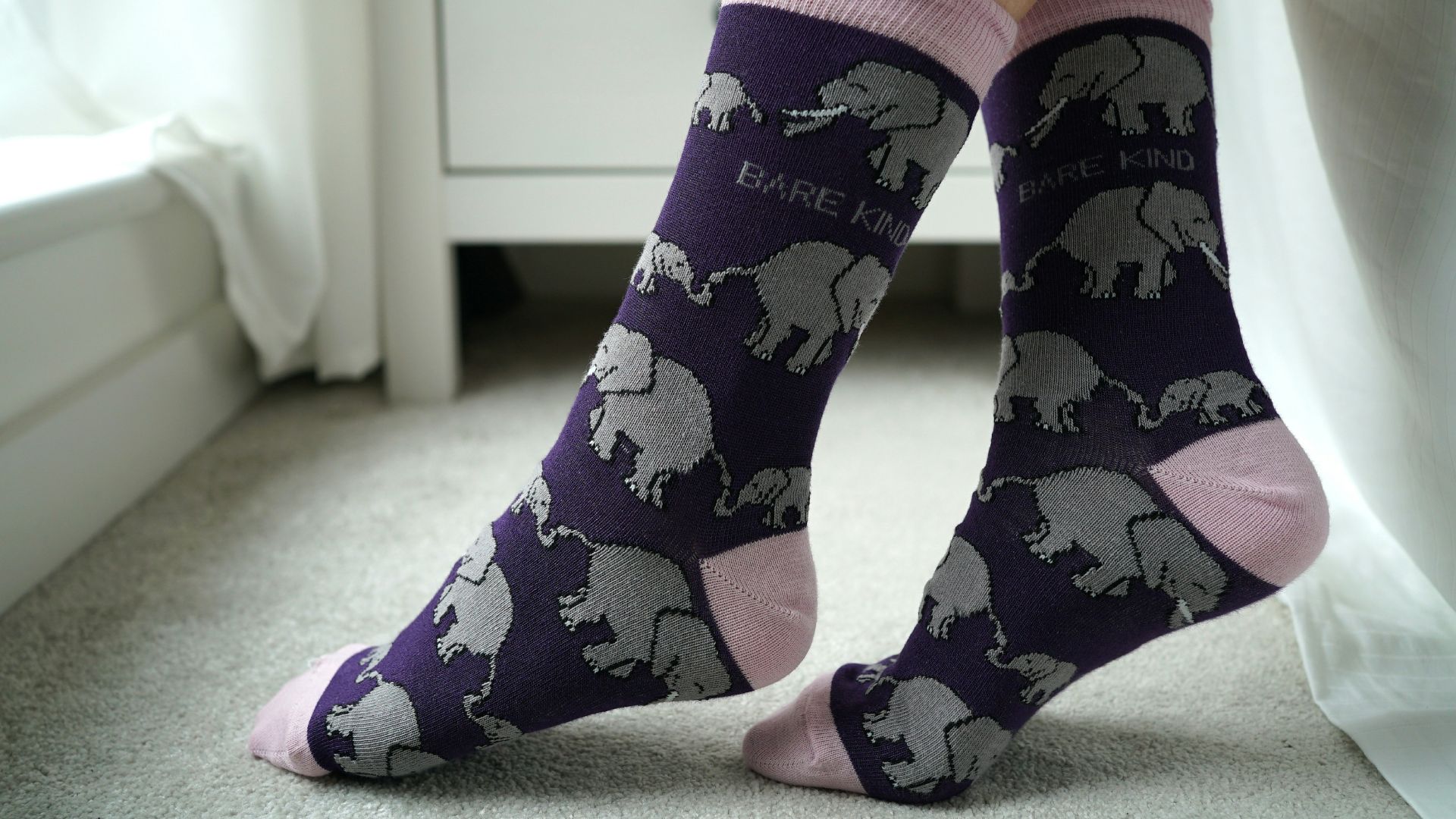A person wearing socks with elephants on them