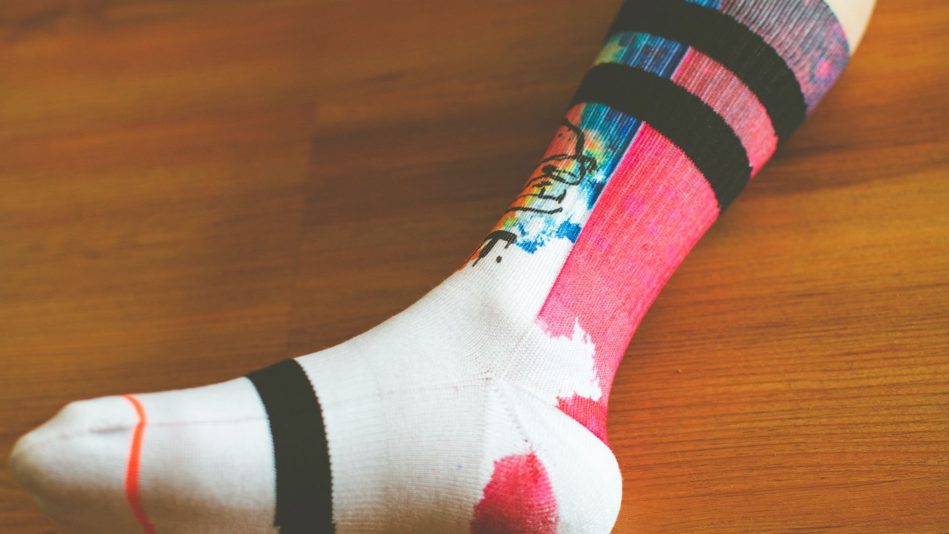 person wearing white green and pink sock
