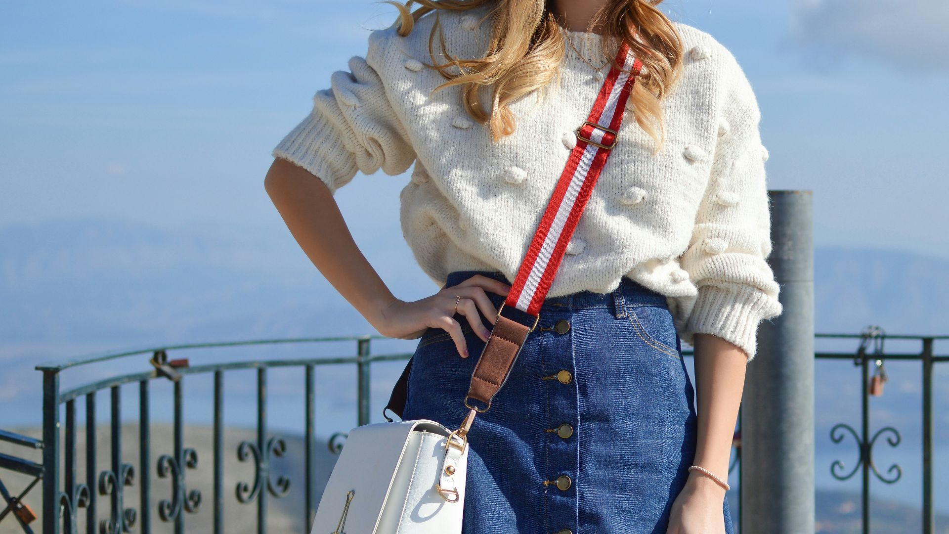 woman standing carrying crossbody bag
