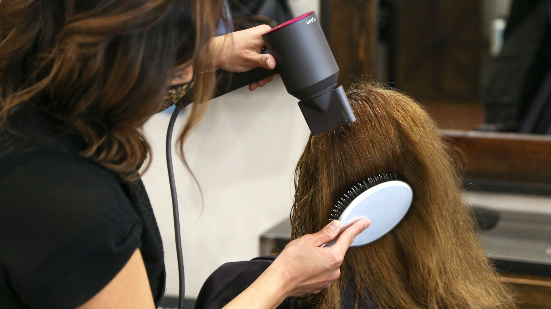 woman holding white and black hair blower