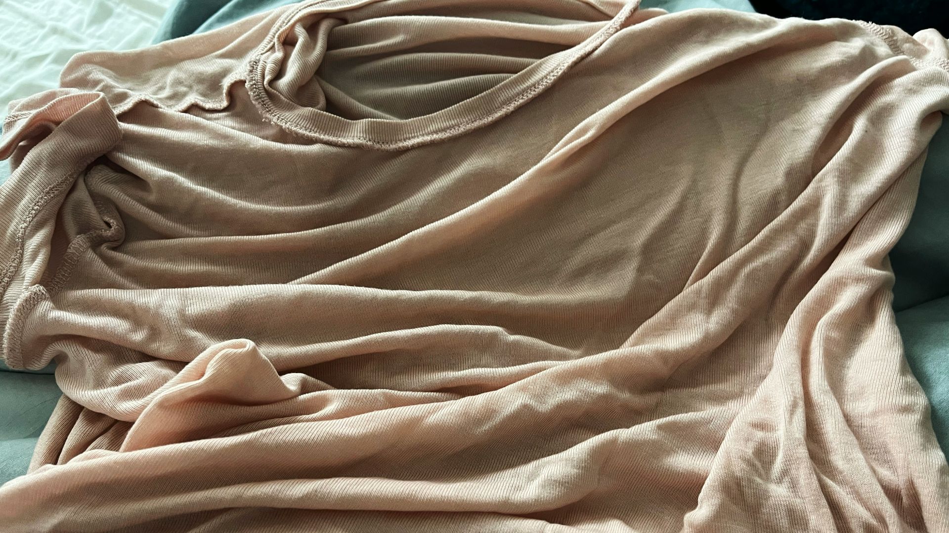A person laying on a bed covered in a blanket