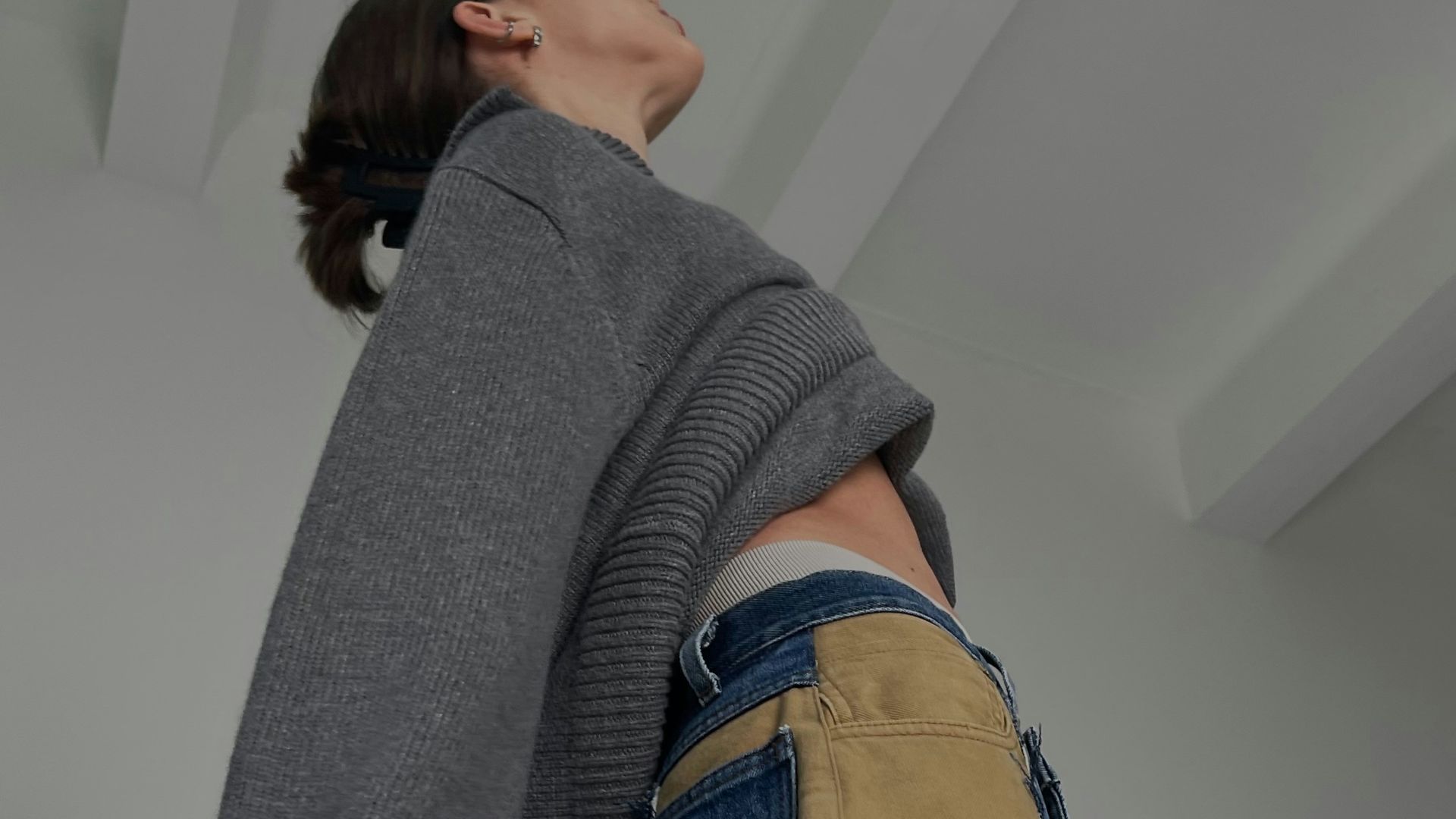 A woman in a sweater and unique pants.