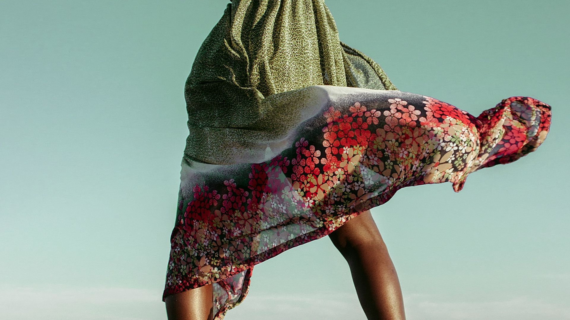 a woman standing on top of a sandy beach