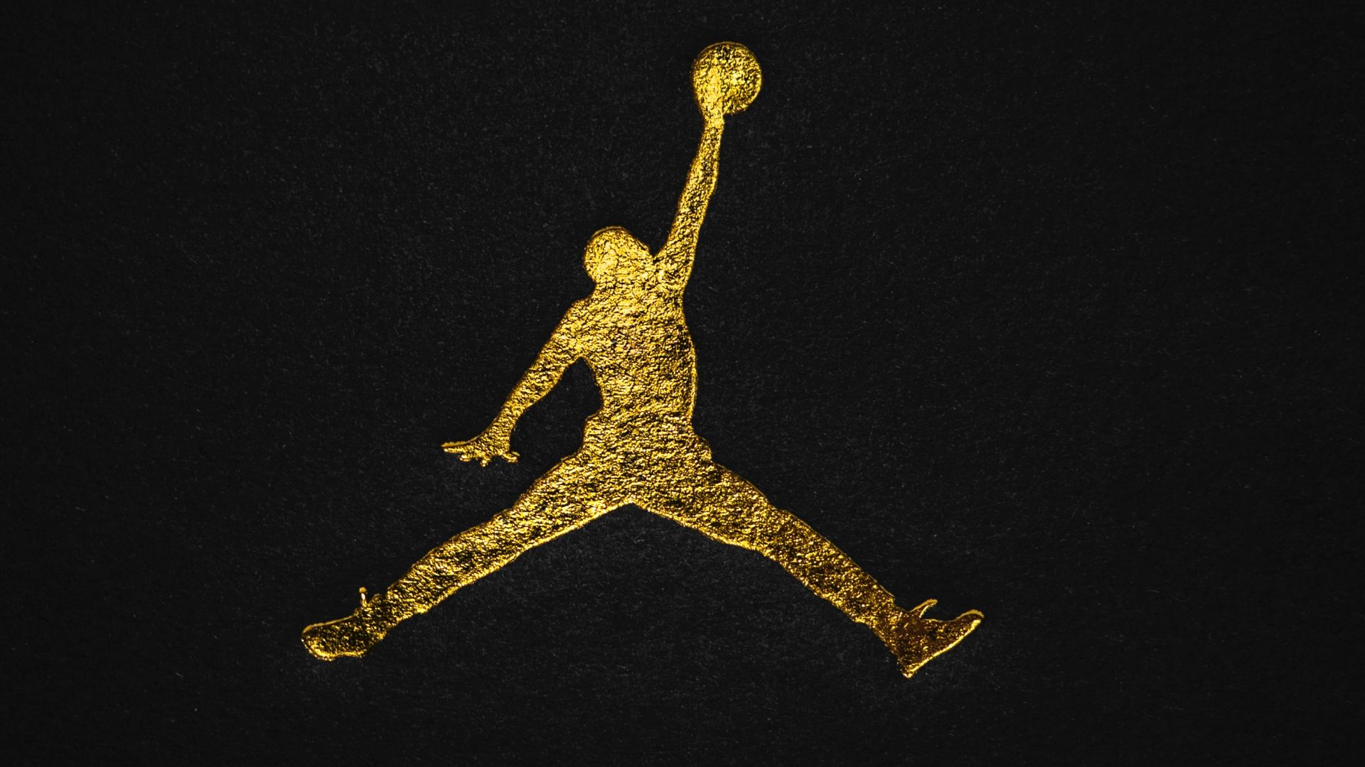 a gold air jordan logo on a black background