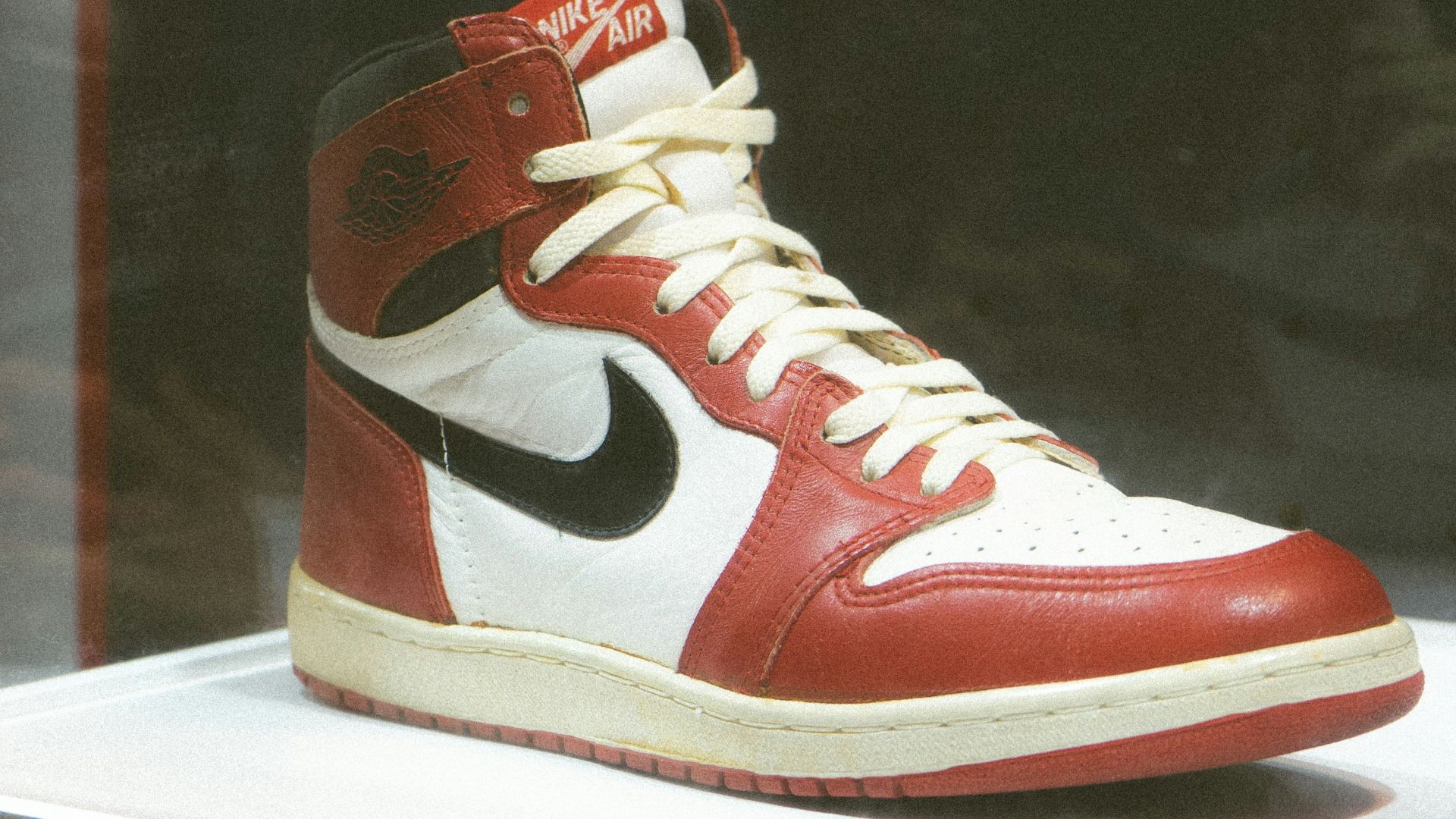 a pair of red and white sneakers on display
