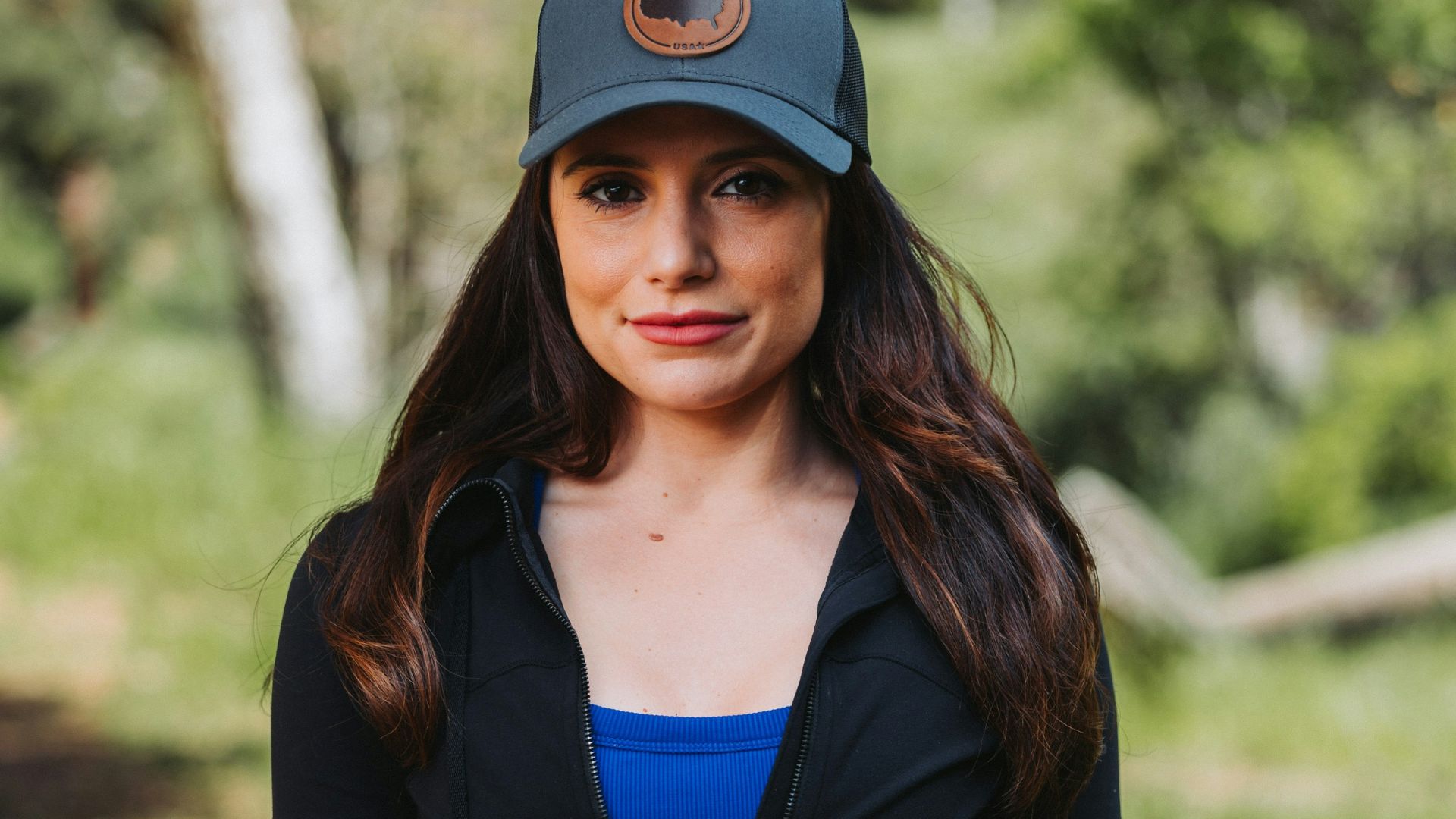 A woman in a black jacket and a blue top