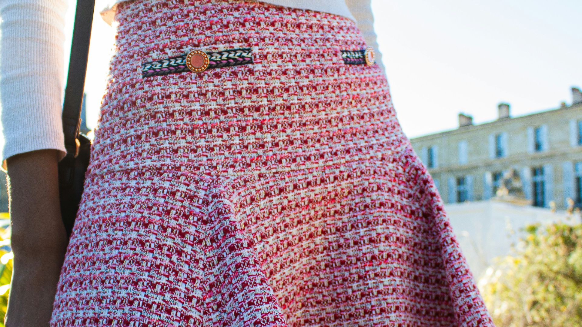 a woman wearing a skirt and a white sweater