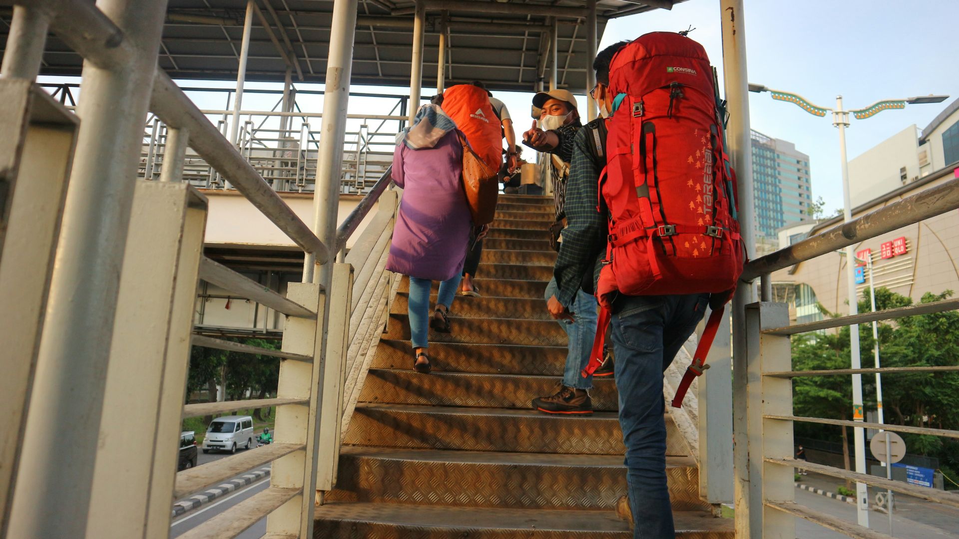 People are walking up stairs with heavy backpacks.