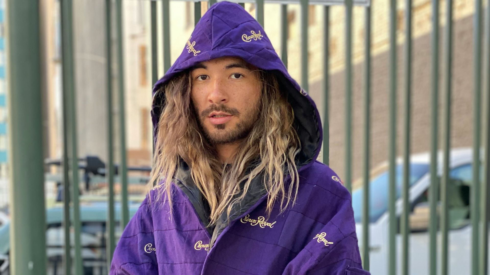 woman in blue zip up jacket standing near white metal fence during daytime