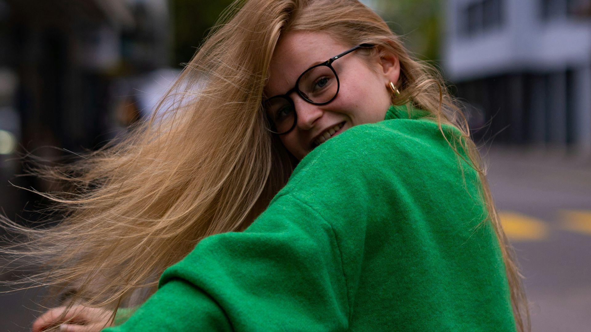 a woman leaning on a rail with her hair blowing in the wind