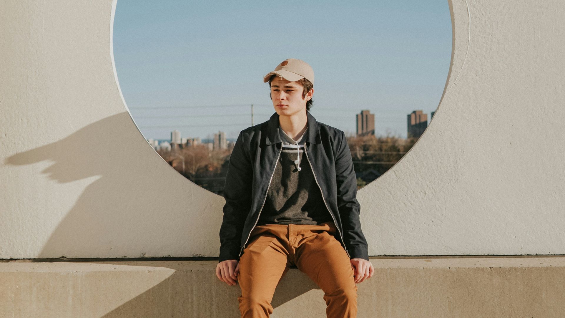 man sitting on gray concrete wall
